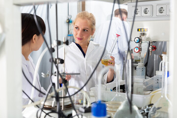 Portrait of male and female scientists in white coats working at biochemical laboratory