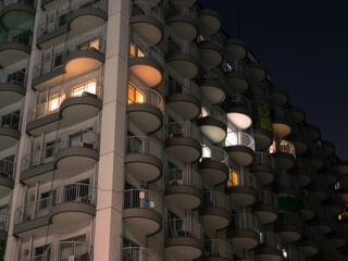 たくさん並んだ丸い形のベランダ　夜のマンション