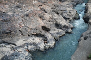 Yogyakarta, Indonesia, Sep 14, 2021. The flow of water with river shoulders in the form of ancient rock textures in the Lava Bantal tourist area.