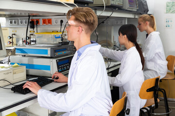 Obraz premium Portrait of young male scientist engaged in research in chemical laboratory with his female colleagues