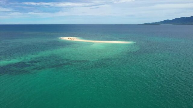 Cinematic shot , aerial view of a small Island, a sand bar in Roxas, Palawan. Summer and travel vacation concept. Tropical islands.Seascape with beautiful sky and islands. Turquoise sea, coral reefs