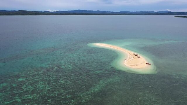 Aerial footage of a small Island, a sand bar in Roxas, Palawan. Summer and travel vacation concept. Tropical islands, top view.Seascape with beautiful sky and islands. Turquoise sea with coral reefs.