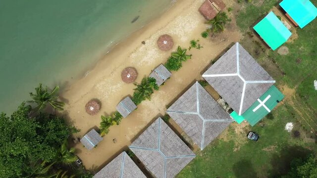 Cinematic shot , aerial  view of a resort on the coast, white sand beach, bungalows in Roxas, Palawan. Summer and travel vacation concept. Tropical islands, top view. Seascape