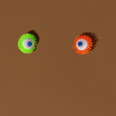 Creative colorful Halloween bloody eyeball on a brown background. Spooky concept.