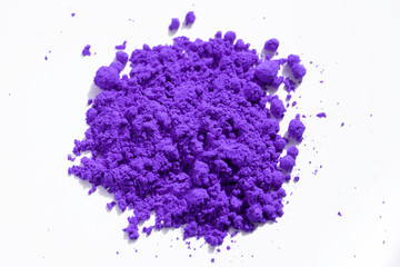 Purple pigment granules and powder strewn on white, viewed from above. The pigment can be used as a base for makeup or mixed with linseed oil to make oil paint