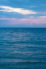 portrait photo of the coastline, with clouds and purplish-blue sky