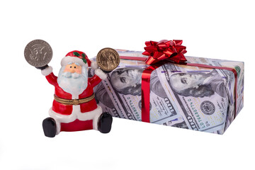 Ceramic Santa Claus figurine with American coins in hands sits on a gift wrapped in paper depicting 100 American dollar bills