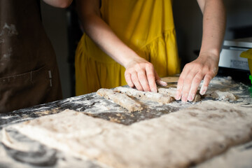 Molding rye sticks with chocolate and hazelnuts by a woman