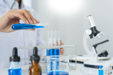 Fototapeta premium scientists researching in laboratory in white lab coat, gloves analysing, looking at test tubes sample, biotechnology concept