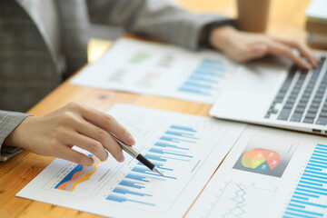 Closeup image of beautiful businesswomen working in office with financial data reports chart