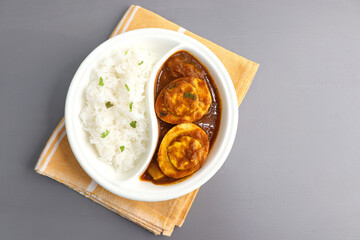 Indian non-vegetarian food  Homemade Egg Curry or Anda masala gravy, baida curry. Served with rice. Indian spicy food. Perfect Indian lunch. over moody background with copy space.