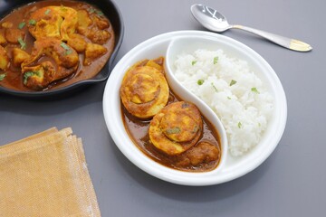 Indian non-vegetarian food  Homemade Egg Curry or Anda masala gravy, baida curry. Served with rice. Indian spicy food. Perfect Indian lunch. over moody background with copy space.