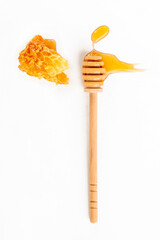 Honey wooden spoon with piece of honeycomb on white background. Organic fresh liquid honey. Healthy food