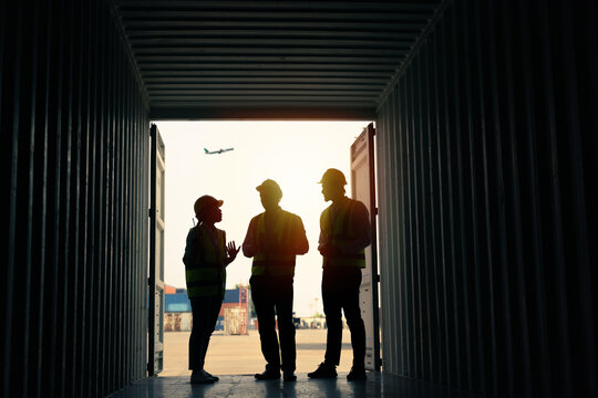 silhouette Group of staff worker standing and checking the containers box from cargo ship for export and import
