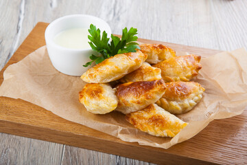 pies with meat and sauce on paper and board