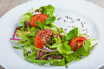 salad with herbs and tomatoes on a plate
