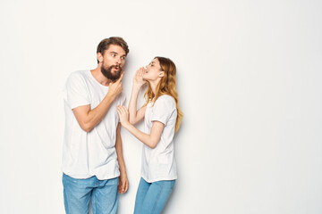 Cheerful man and woman in white t-shirts embrace friendship together