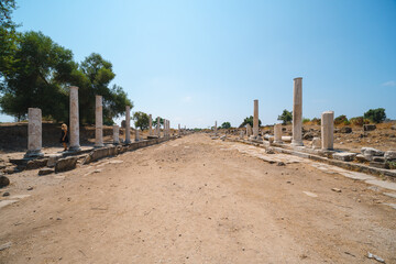 Fototapeta na wymiar The ancient roman ruins situated in the turkish town of Side Road, stone columns, stones. Turkey