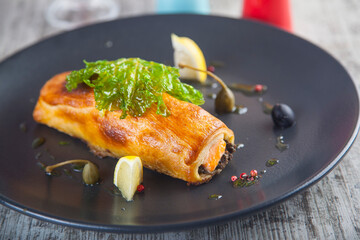 baked fish in dough on a white plate with pesto sauce