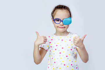 A female child in glasses with an occluder on the eye shows the class with a gesture.