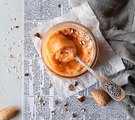 Honey souffle. Whipped honey with apricot and almonds glass jar on a light background. Top view. Flat lay