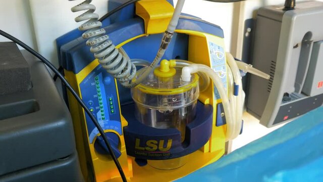 Laerdal portable suction unit (LSU)  inside the emergency medical service vehicle, used for safe and effective clearing of the patient’s airway, paramedic equipment, handheld medium shot