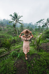 Girl in a hat walks in a rice field, Bali, Indonesia.