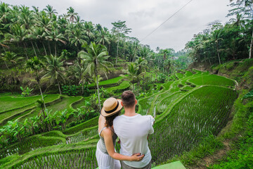 Сouple in love walking in a rice field, Bali, Indonesia.