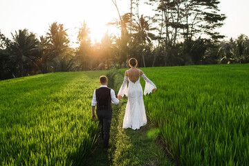 Сouple in love walking in a rice field, Bali, Indonesia.