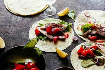 Corn tortillas stuffed with chicken and vegetables on a wooden table. Cooking tacos.