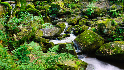 Slowmotion water stream creating a path through the boulders