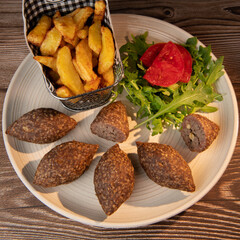 Traditional kebbe and pita bread on big round plate in lebanese restaurant. High quality photo