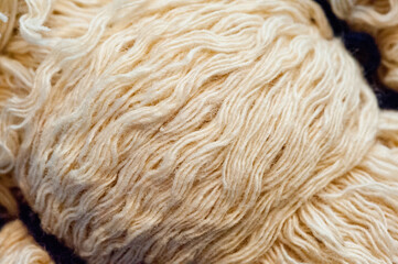 Close-up shot of a skein of beige woolen thread.