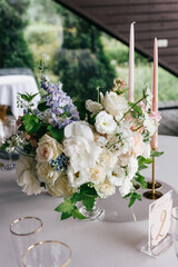 Floral wedding decoration. Wedding table setting decorated with fresh flowers. Wedding floristry. Bouquet with roses, eustoma and eucalyptus leaves.