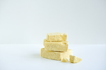 Isolated bars, pieces of cocoa butter on a white background. Benefits of cocoa butter for beauty and health. Organic natural products. Minimalism and simplicity. Cosmetic and cook concept still life.