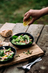 Salad with seafood, vegetables and herbs in a plate on a wooden table. Rustic style
