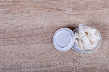 snus. tobacco in bags. the background is wooden in a retro style. there is a tinting. close-up.