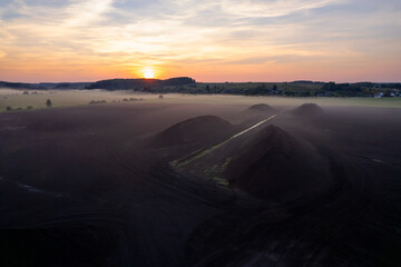 Peat extraction site in fog on sunset. Collecting peat on peatlands. Mining and harvesting...