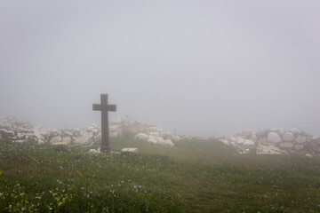 Foggy landscape with spooky stone cross, Khvamli Mountain, Georgia, Halloween motif, copy space.