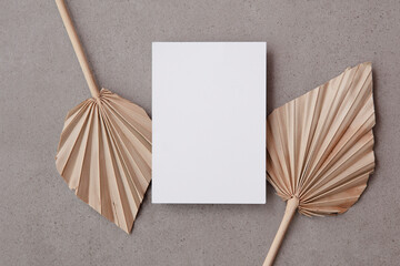 Blank invitation card for a natural wedding or celebration event with dried palm leaf stem