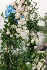 Naklejka na ściany i meble Luxury wedding arch with lush leaves, delicate roses and purple hydrangea outdoors. Wedding floristry