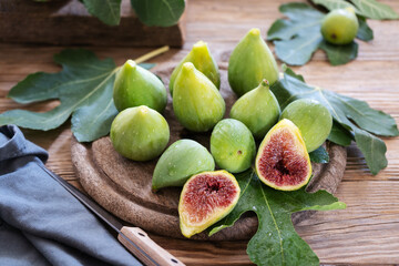 Green figs on the cutting board with leaves 