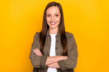 Photo of cheerful confident happy young woman hold hands folded isolated on yellow color background