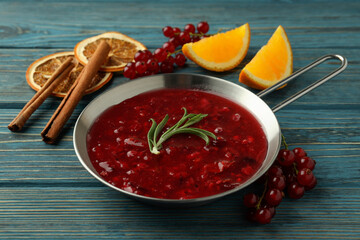 Cranberry sauce and ingredients on wooden background