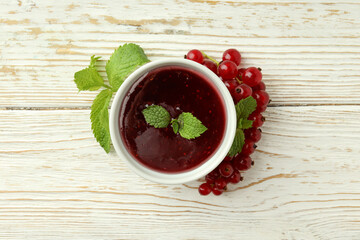 Bowl of cranberry sauce on white wooden background