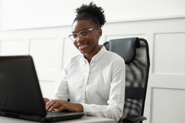 african businesswoman in the office behind a laptop