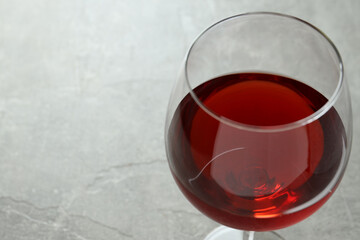 Glass of red wine on gray textured background