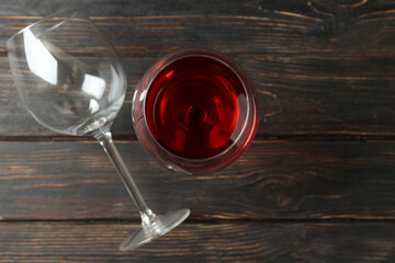 Glass of red wine and empty glass on rustic wooden background
