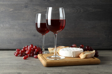 Concept of tasty eating with red wine on gray textured table