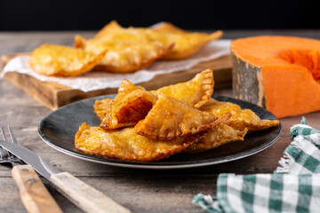 Pumpkin empanadillas on wooden table